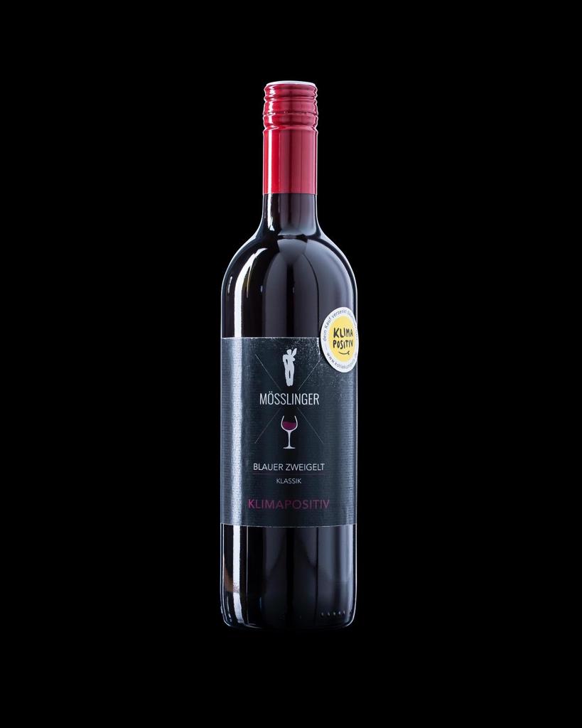 Weinflasche der Sorte Blauer Zweigelt mit rotem Etikett und dem klimapositiv Label