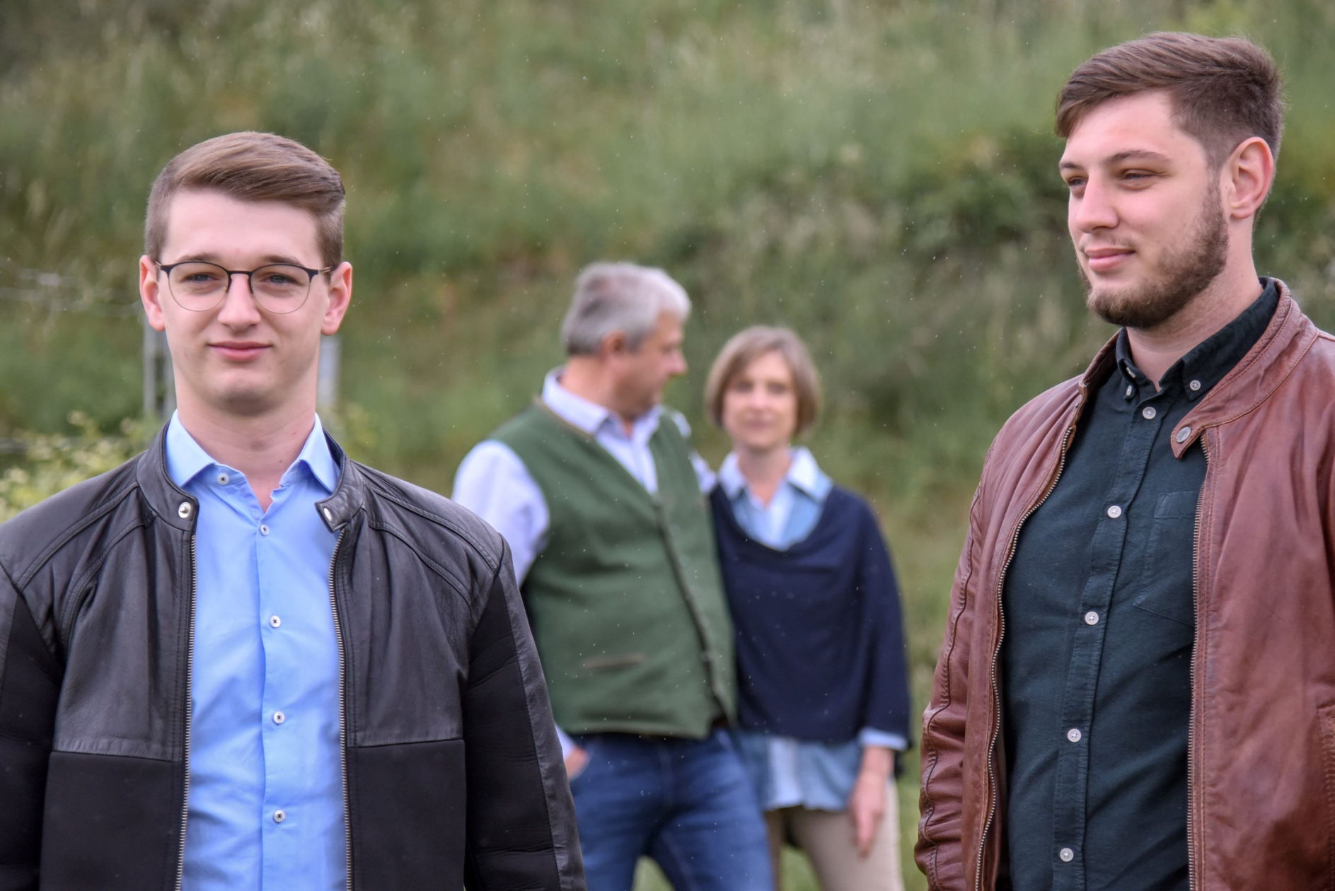 Familie Mößlinger auf dem Weinberg im Vordergrund die beiden erwachsenen Söhne