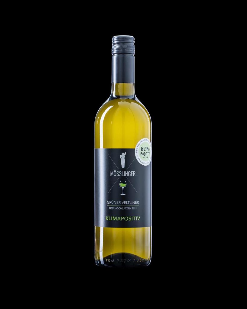 Weinflasche der Sorte Grüner Veltliner mit dem klimapositiv Label auf schwarzem Hintergrund